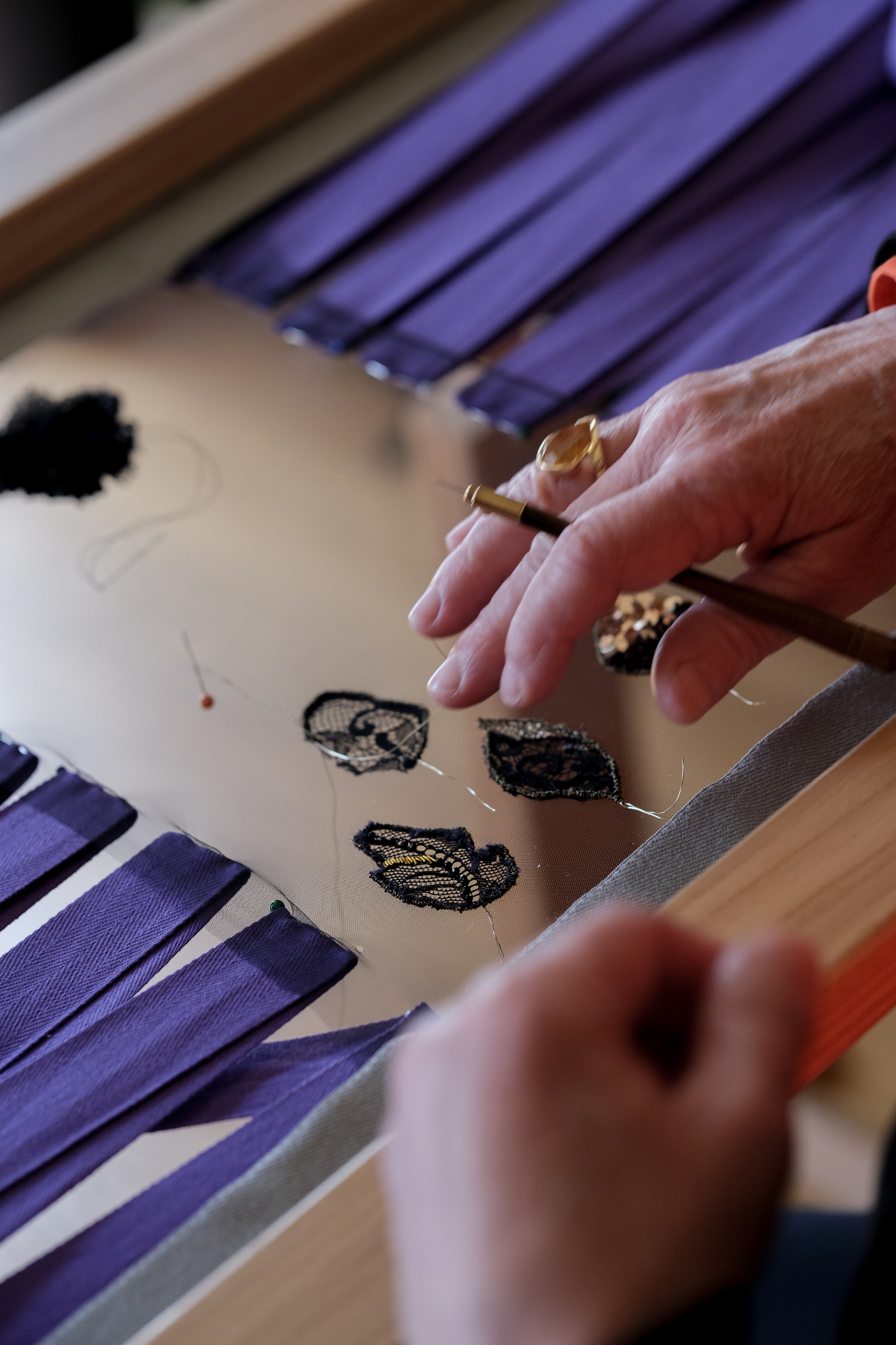 Détail des mains de Ghislaine Bascou brodant à la main avec la technique du crochet de Lunéville