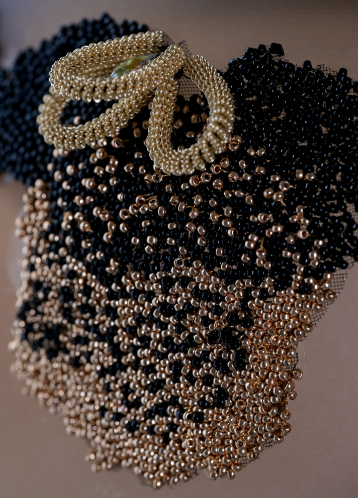 detail_broderie_sur_bouteille_de_vin Gros plan sur une création brodée de Ghislaine Bascou alliant perles, textures et motifs inspirés de la nature